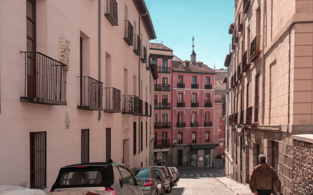 Espanjassa sijaitsevat vanhat kerrostalot, joiden keskellä kulkee autotie.