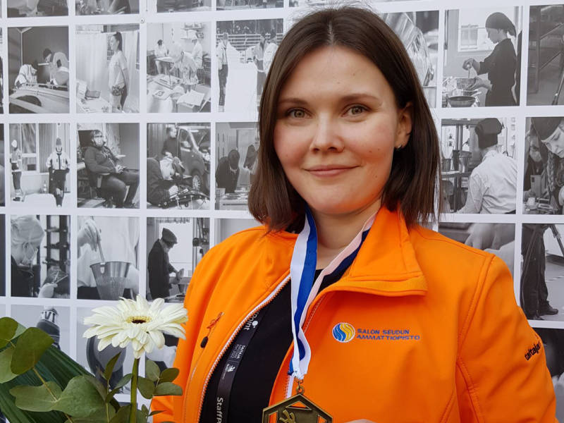 Teknisen suunnittelun opiskelija Niina Virkki poseeraa mitali kaulassa.