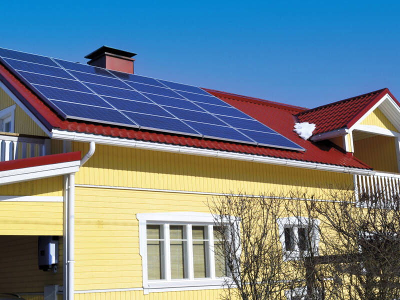Solar Finlandin asennuttamat aurinkopaneelit keltaisen omakotitalon katolla.