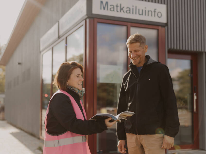 Opiskelija matkailualalta toimii oppaana ulkona esitellen kohteen nähtävyyksiä.