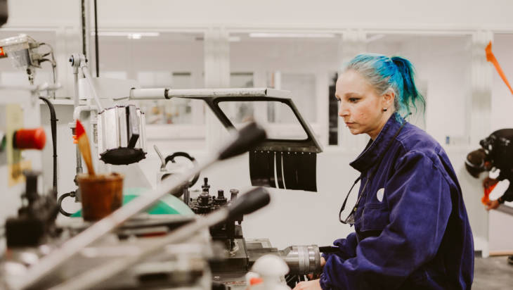 Metallialan opiskelija käyttää manuaalisorvia valoisassa kone- ja tuotantotekniikan oppimisympäristössä Salon seudun ammattiopistolla.