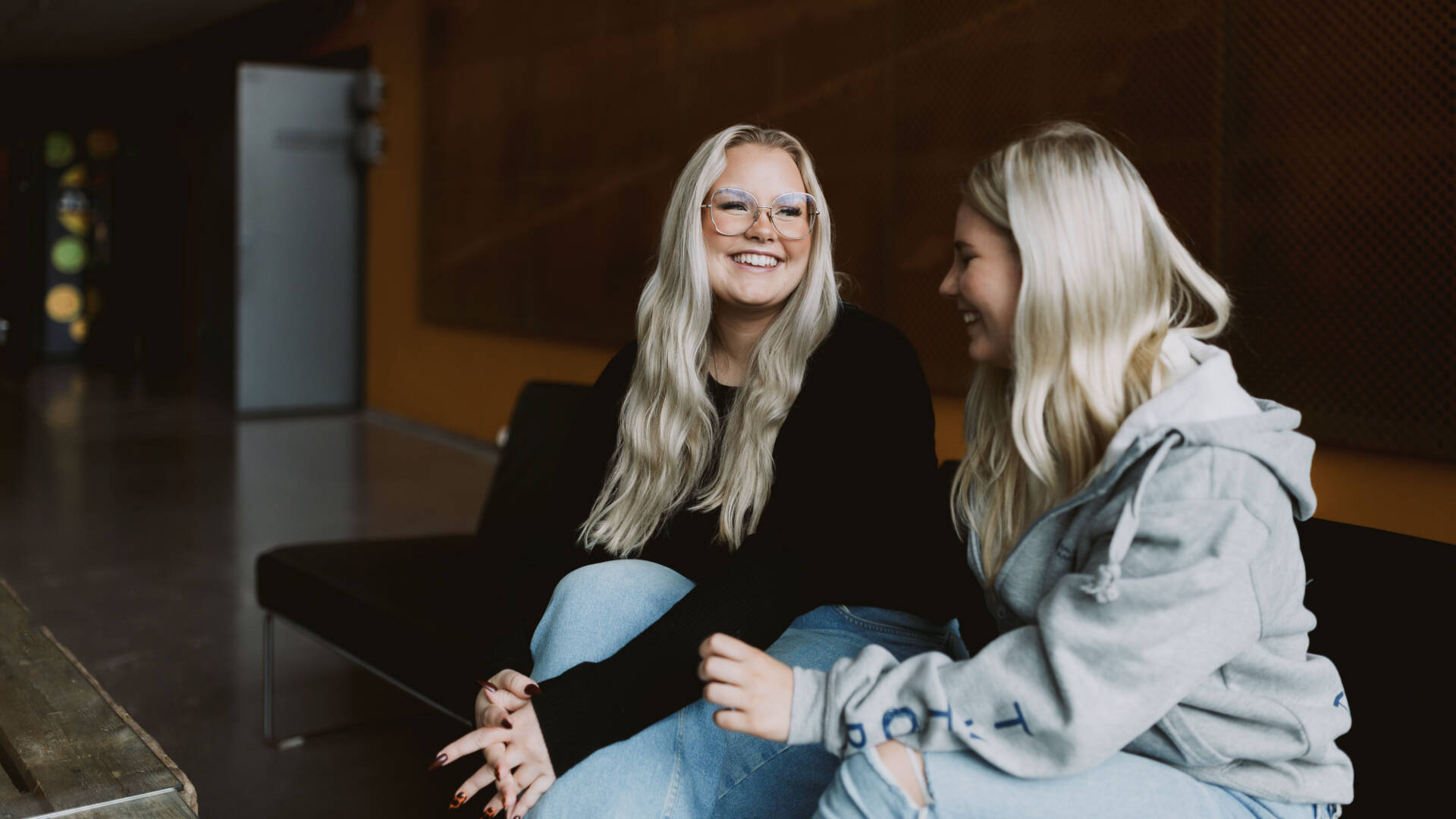 Iloiset opiskelijat keskustelevat Salon seudun ammattiopiston aulatilassa.