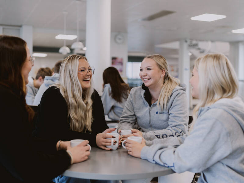 Opiskelijat keskustelevat yhteisöpedagogin kanssa Salon seudun ammattiopiston aulatilassa.