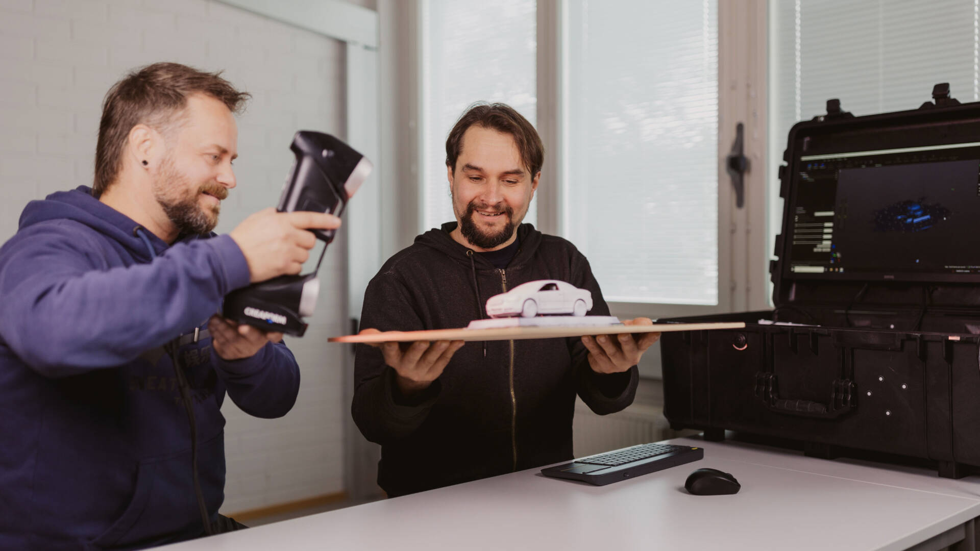 Opiskelijat teknisen suunnittelun alalta hyödyntävät 3D-skanneria auton pienoismallin digitointiin.