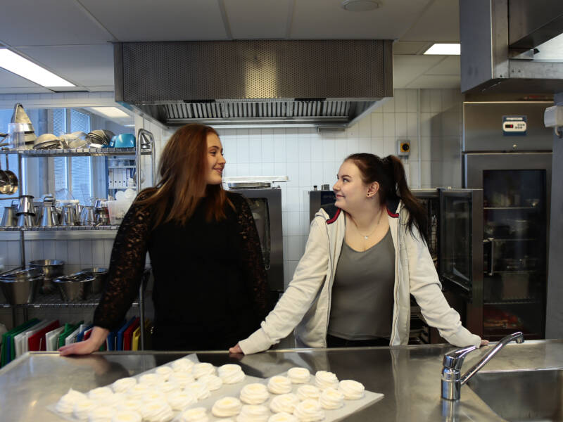 Kaksi ravintola-alan Taitaja 2024 finalistia keittiössä katsovat toisiaan.